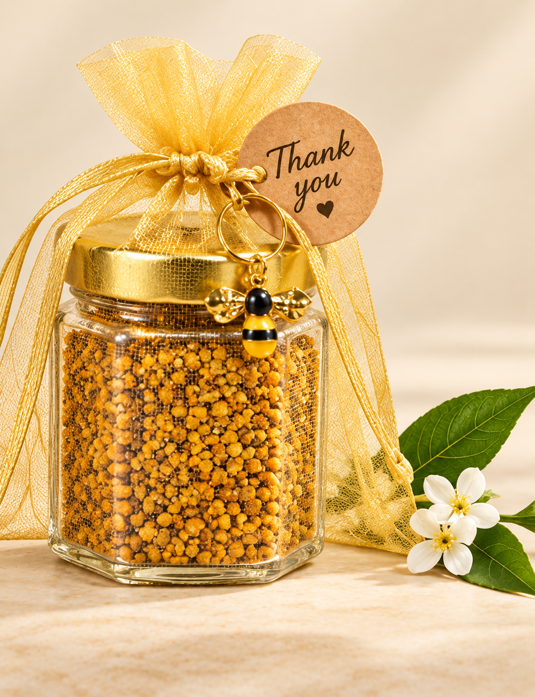 A 2.5 oz jar of golden bee pollen presented in a gift bag with a bee charm