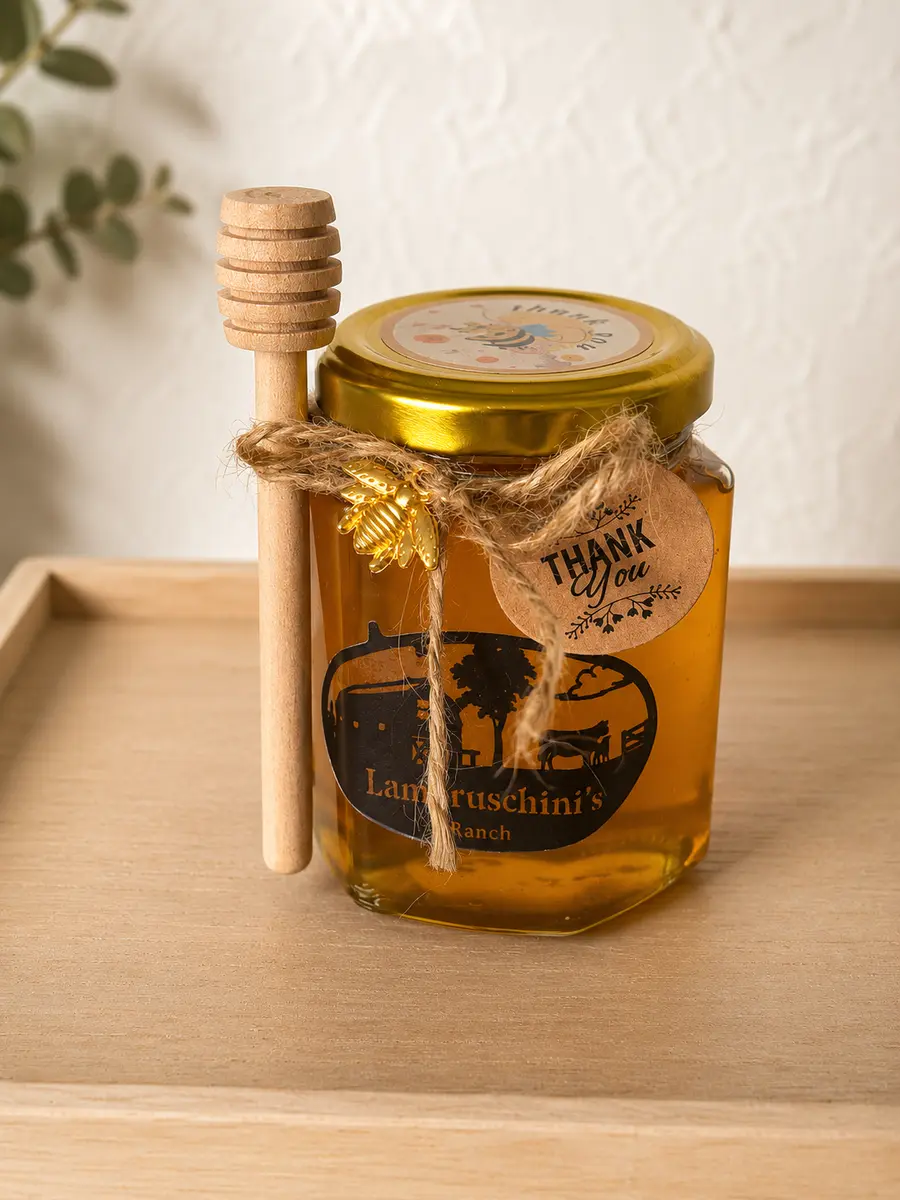 Large 6 oz jar of Orange Blossom Raw Honey with a wooden honey dipper